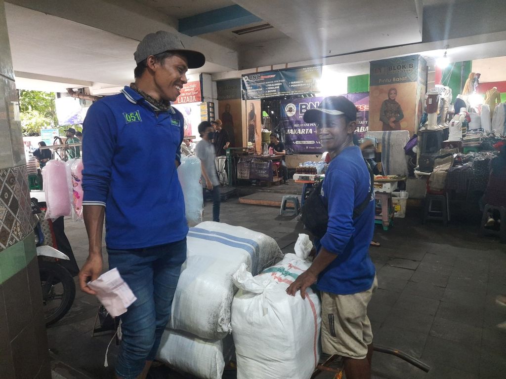 Ramin (40) dan rekannya bersiap mengangkut barang di Pasar Tanah Abang, Jakarta, Kamis (9/3/2023).