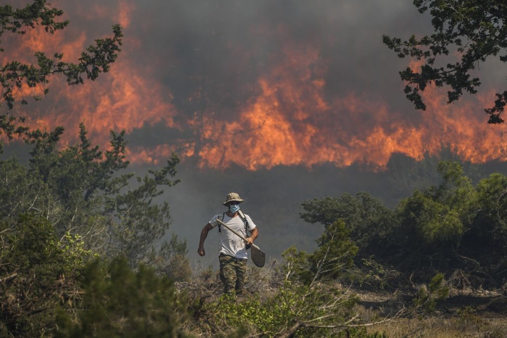 Kebakaran hutan terjadi di Desa Vati, di Pulau Rhodes, Yunani Utara, Selasa (25/7/2023). Gelombang panas yang terjadi berturut-turut di Yunani mendorong suhu kembali di atas 40 derajat celsius.