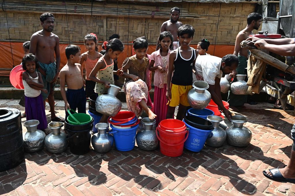 Para pengungsi Rohingya mengantre untuk memperoleh jatah air minum dari sebuah tangki di kamp pengungsi Kutupalong, Ukhia, Cox's Bazar, Bangladesh, 29 September 2022. 