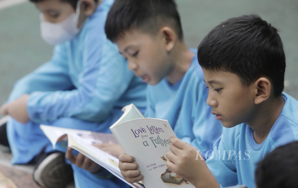 Siswa membaca buku koleksi perpustakaan keliling di Sekolah Dasar Negeri 01 Kebon Manggis, Jakarta Timur, Selasa (23/4/2024). Sebagian besar pekerja di Indonesia memiliki latar belakang pendidikan yang belum memadai.