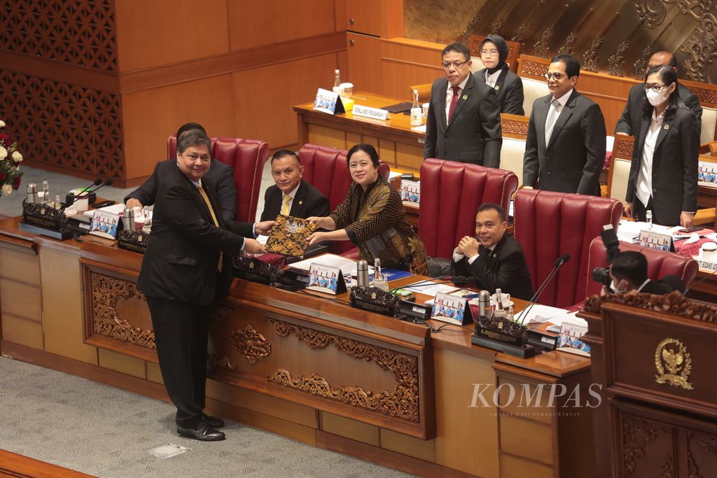 Menteri Koordinator Bidang Perekonomian Airlangga Hartarto (kiri) menyerahkan pandangan pemerintah kepada Ketua DPR Puan Maharani saat rapat paripurna di Kompleks Parlemen, Senayan, Jakarta, Selasa (21/3/2023). 