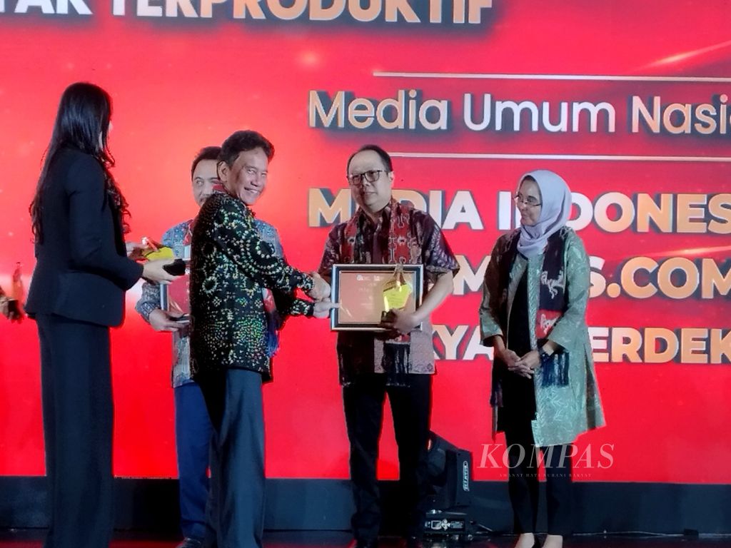 Pemimpin Redaksi Harian <i>Kompas</i> Sutta Dharmasaputra (kedua dari kanan) menerima plakat penghargaan dari Wakil Ketua Dewan Komisioner Otoritas Jasa Keuangan (OJK) Mirza Adityaswara (kedua dari kiri) dalam Apresiasi Media Massa 2023, di Jakarta, Senin (27/11/2023).