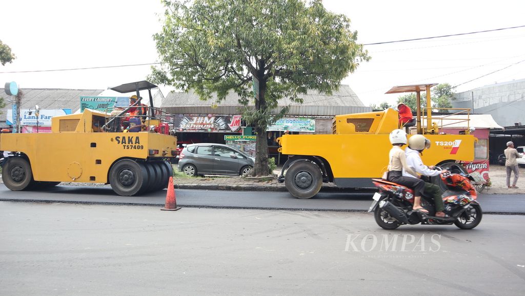 Petugas mengoperasikan alat berat untuk mengaspal jalan di Jalan Dewi Sartika, Kabupaten Cirebon, Jawa Barat, Minggu (2/4/2023). 