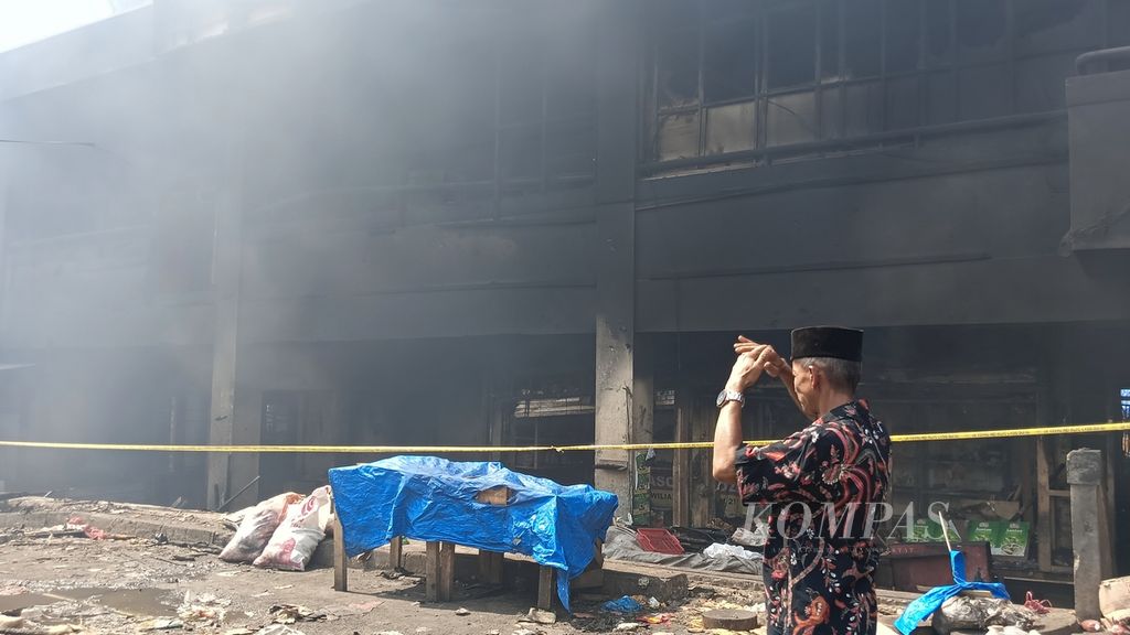 Seorang pedagang menahan hawa panas dari kebakaran di pasar Leuwiliang, Kabupaten Bogor, Jawa Barat, Kamis (28/9/2023). Kebakaran yang terjadi pada Rabu (27/9/2023) malam masih mengeluarkan asap pekat hingga pukul 13.00, Kamis.