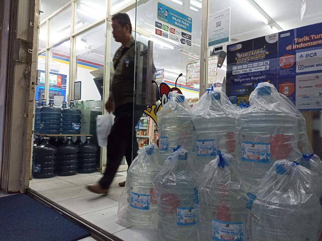 A shop visitor passes near bottled water in gallons being sold at a mini market in Medan, North Sumatra, on Tuesday (13/9/2022).