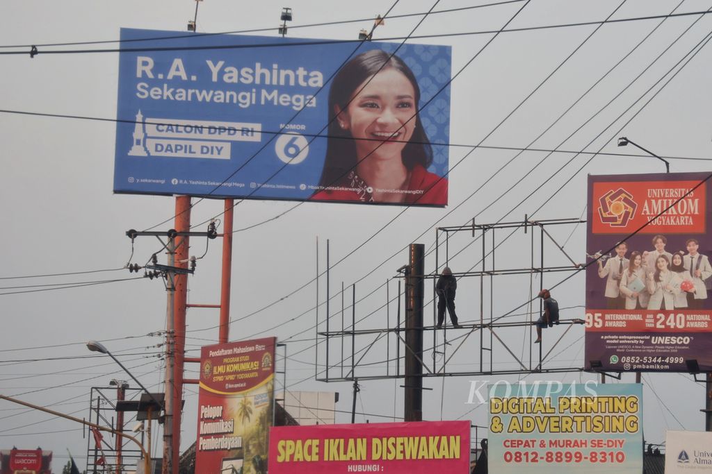Pekerja memperbaiki rangka baliho iklan di Simpang Dongkelan, Bantul, DI Yogyakarta, Sabtu (7/10/2023). Gencarnya upaya para politikus yang hendak mencalonkan diri dalam pesta demokrasi mendatang membawa angin segar bagi pelaku usaha di bidang periklanan.