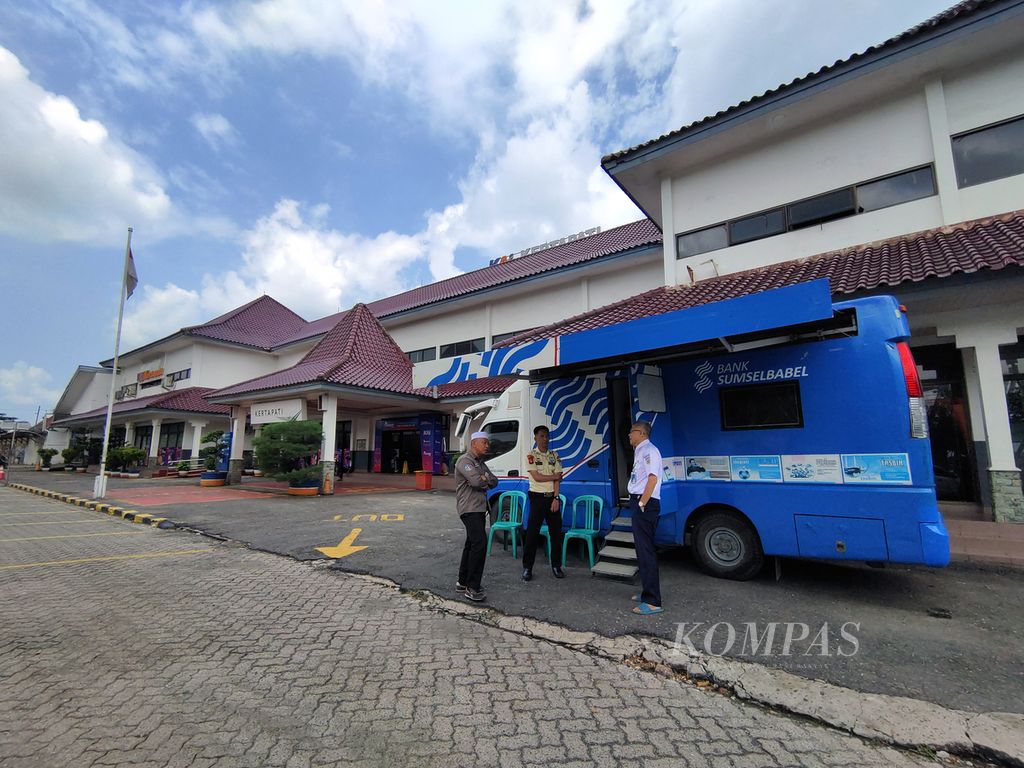 Petugas menjaga mobil layanan pendaftaran program Gerakan Mudik Gratis Serentak Se-Sumatera Selatan untuk moda transportasi kereta api di halaman Stasiun Kertapati, Palembang, Sumatera Selatan, Jumat (22/3/2024). 