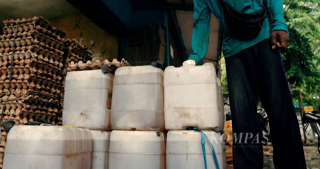 Pekerja bersiap memindahkan jeriken minyak goreng 16 liter di Pasar Pulojae, Cakung, Jakarta Timur, Kamis (6/1/2022).  