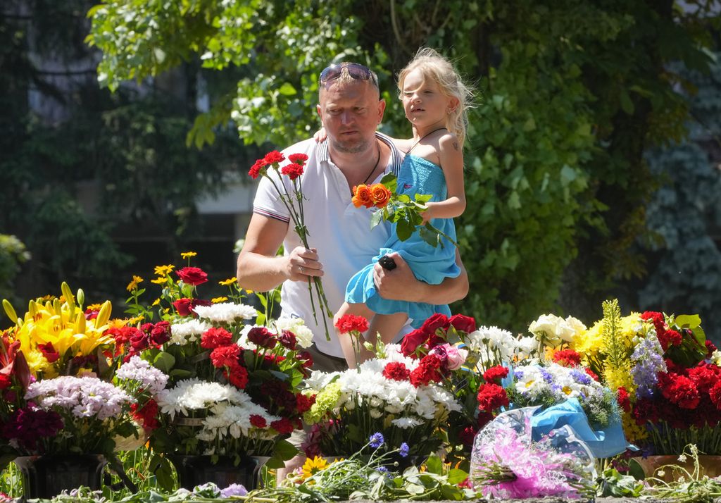 Warga meletakkan bunga bagi korban serangan Rusia di pusat perbelanjaan di Kremenchuk, Ukraina, 29 Juni 2022. 