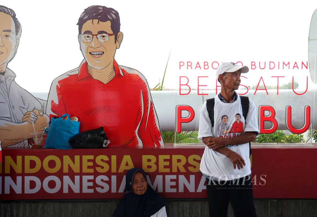 Warga yang berdiri dengan latar belakang karikatur Budman Sudjatmiko saat deklarasi sukarelawan Prabowo Budiman (Prabu) di Marina, Kota Semarang, Jawa Tengah, Jumat (18/8/2023). 