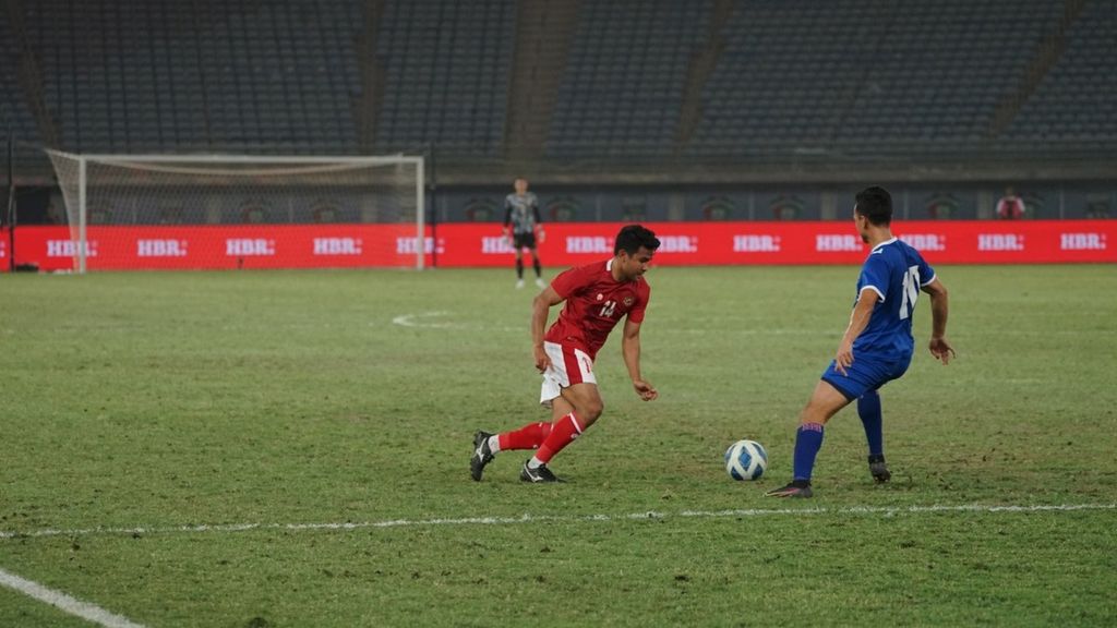 Asnawi Mangkualam, bek sayap Indonesia, menggiring bola untuk melewati pemain Nepal pada laga kualifikasi Piala Asia 2023, Rabu (15/6/2022) dini hari WIB, di Stadion Internasional Jaber Al-Ahmad, Kuwait City. Pada laga itu, Asnawi menciptakan dua asis bagi dua gol perdana ”Garuda” di babak pertama.