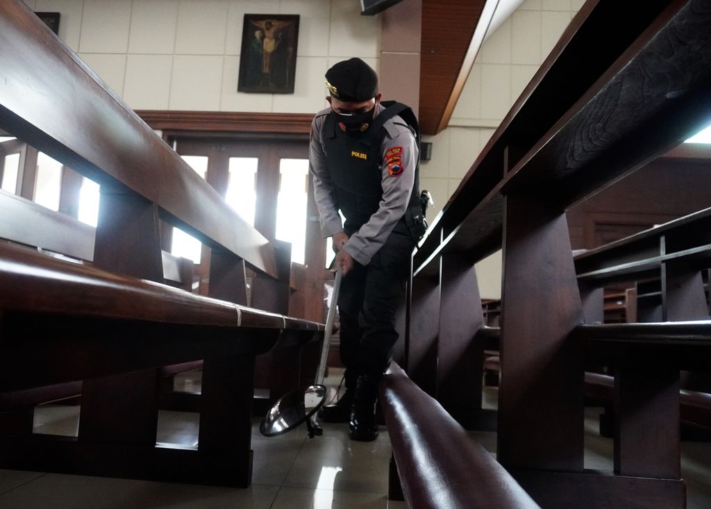 Polisi mengecek kursi di Gereja Katolik Hati Kudus Yesus Kota Tegal, Jawa Tengah, Kamis (1/4/2021). Selama Trihari Suci, gereja-gereja disterilkan dan pengamanannya diketatkan untuk mengantisipasi tindakan terorisme. 