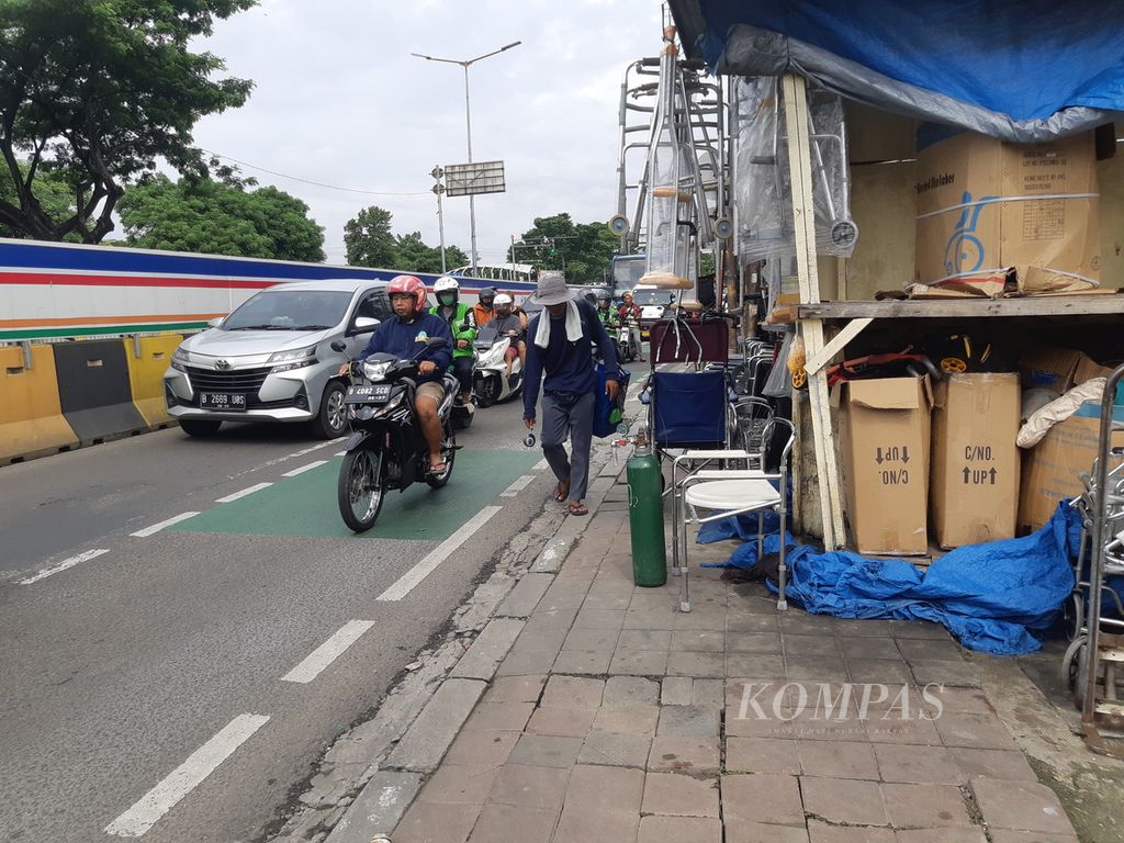 Kondisi trotoar di sekitar kawasan Pasar Rumput, Jakarta Selatan, yang terokupasi pedagang barang bekas, Minggu (3/3/2024). Situasi ini mengancam pejalan kaki yang berisiko terserempet kendaraan. 