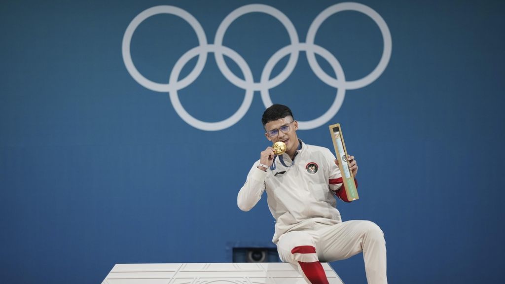 Lifter Indonesia, Rizki Juniansyah, berpose dengan medali emas yang diraihnya pada cabang angkat besi kelas 73 kilogram Olimpiade Paris 2024 di Paris, Perancis, Jumat (9/8/2024) dini hari WIB. Ia menjadi atlet kedua Indonesia yang meraih emas di Paris 2024.