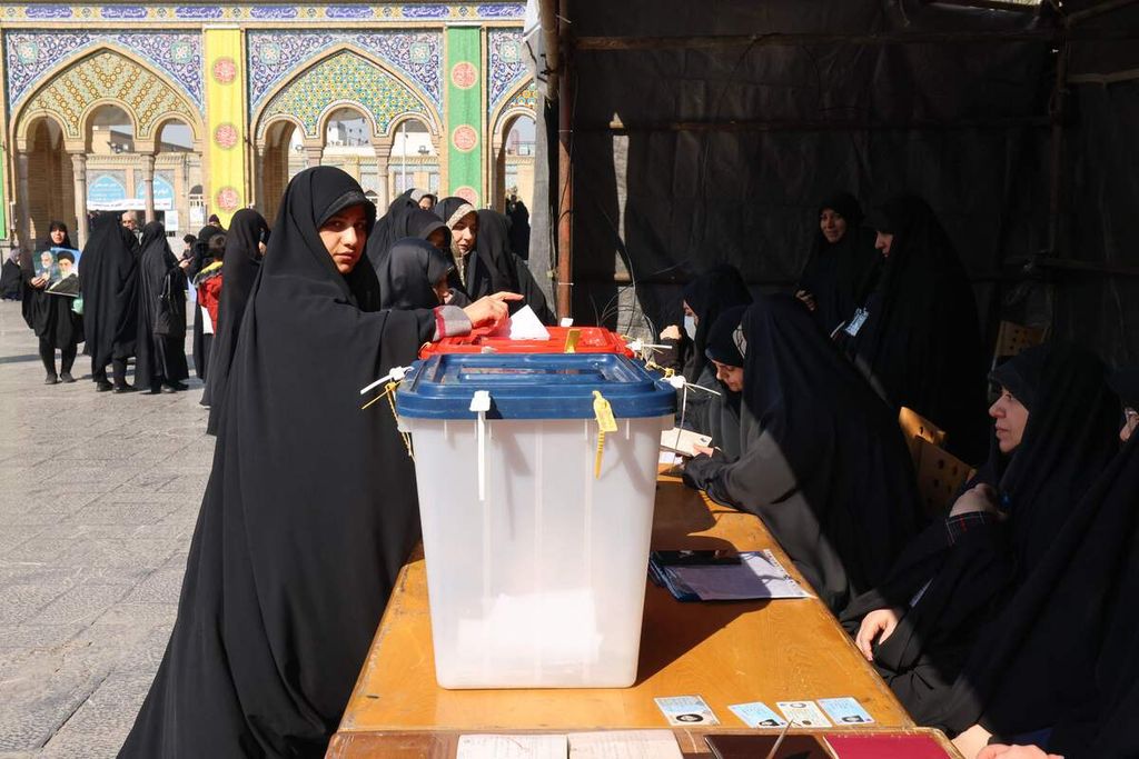 Seorang perempuan warga Iran memasukkan kertas suaranya di kotak suara dalam pemilihan umum legislatif dan Majelis Pakar di sebuah tempat pemungutan suara di Teheran, Iran, Jumat (1/3/2024). 