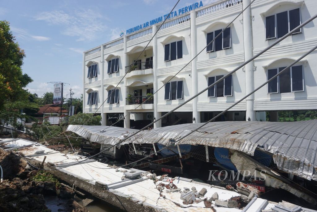 Tujuh unit kendaraan dinas Perusahaan Umum Daerah Air Minum Tirta Perwira Purbalingga tertimpa atap setelah tembok keliling di sekitarnya ambruk tergerus aliran air sungai pada Kamis (4/4/2024).