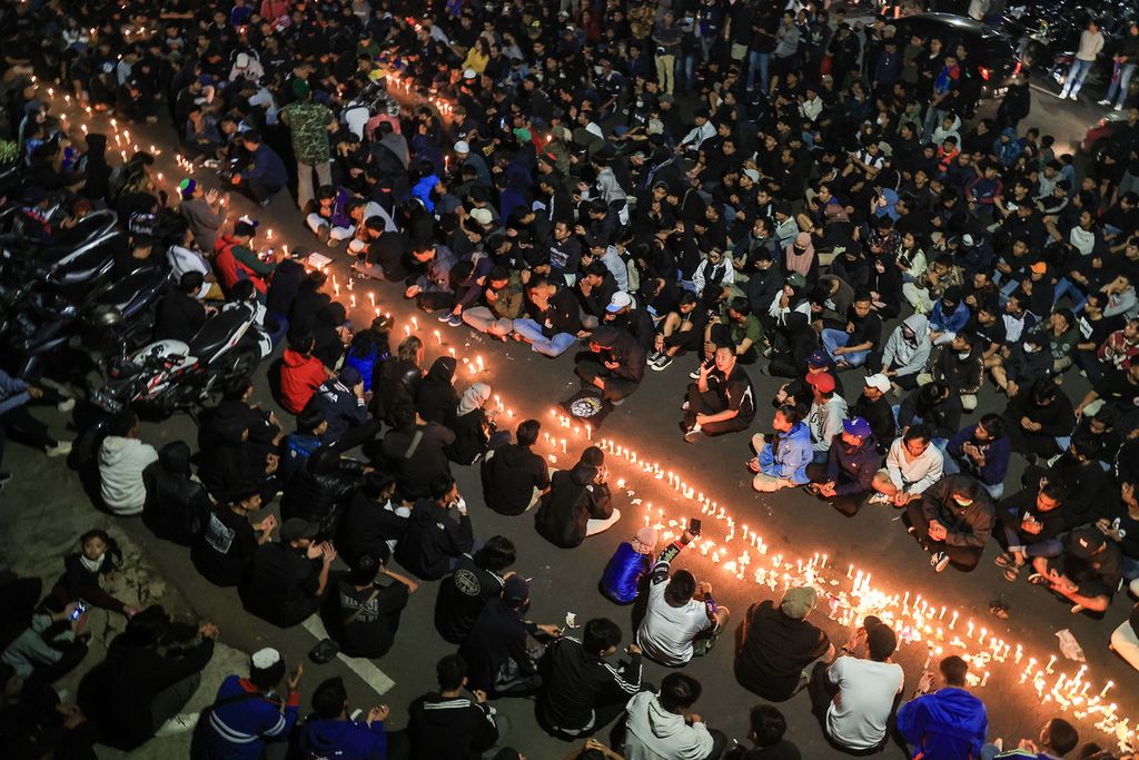 Ribuan Aremania melakukan doa bersama di luar Stadion Gajayana, Malang, Jawa Timur (2/10/2022). Mereka menyalakan lilin dan doa bersama untuk korban tragedi Kanjuruhan yang merenggut 134 nyawa. 