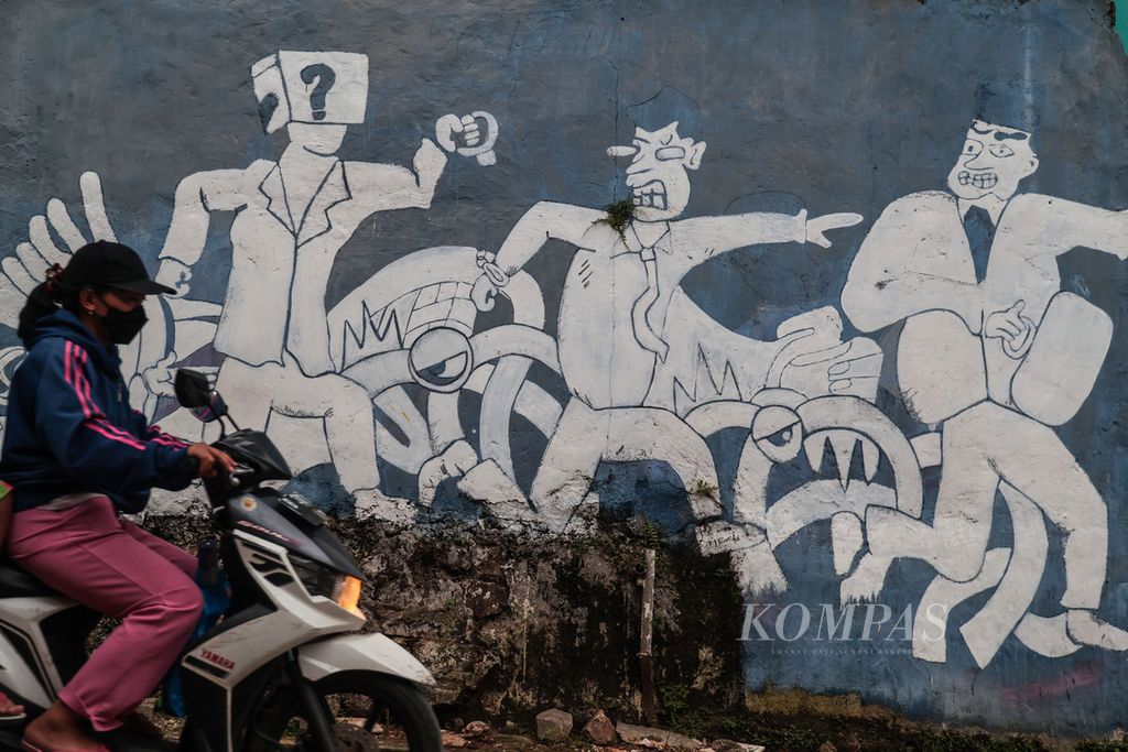 Warga melintas di depan mural bertema penegakan hukum di kawasan Buaran, Tangerang Selatan, Banten, Minggu (11/12/2022). Masa transisi tiga tahun sebelum penerapan Kitab Undang-undang Hukum Pidana (KUHP) baru akan dimanfaatkan pemerintah untuk sosialisasi masif kepada aparat penegak hukum.