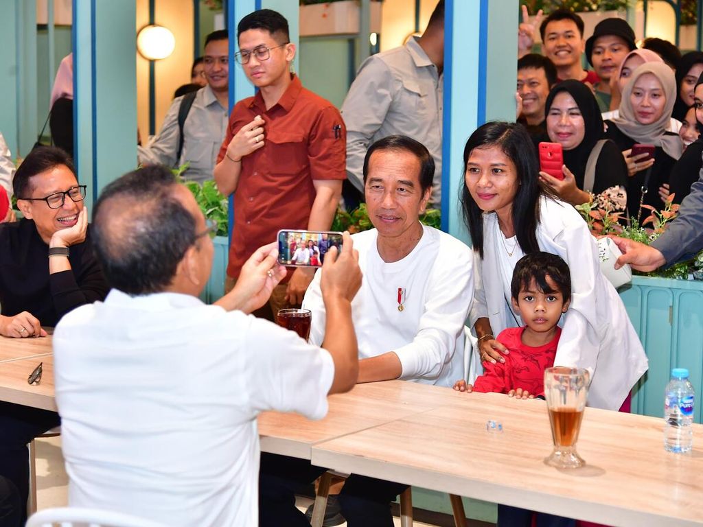 Menteri Sekretaris Negara Pratikno mengambilkan foto Presiden Joko Widodo bersama pengunjung pusat perbelanjaan The Park, Kendari, Sulawesi Tenggara, Minggu (12/5/2024).