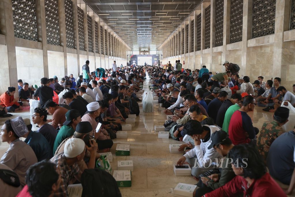 People waiting to break their fast at Istiqlal Mosque in Jakarta, on Tuesday (12/3/2024). Hundreds of people broke their fast together on the first day of Ramadan 1445 Hijriah/2024 at Istiqlal Mosque. The managers of Istiqlal Mosque provide 4,000-6,000 food boxes every day for breaking the fast during Ramadan.