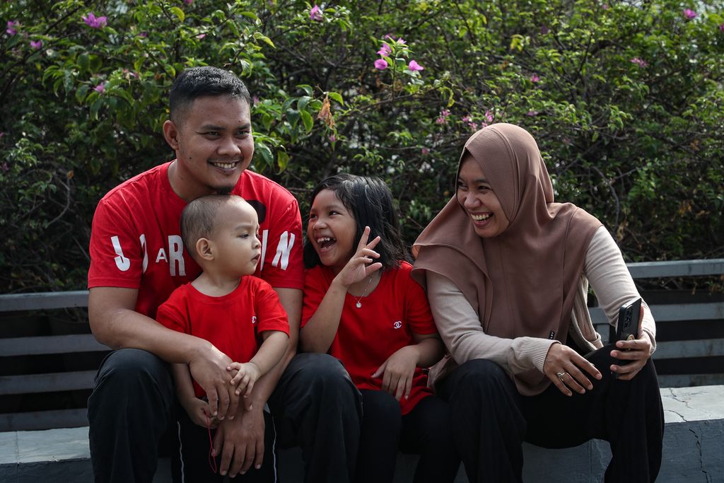 Satu keluarga bergurau saat hari bebas kendaraan bermotor di kawasan Bundaran HI, Jakarta, Minggu (28/5/2023). 