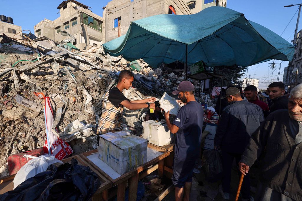 Warga Palestina menjual barang-barang di depan sebuah bangunan yang sebelumnya terkena serangan Israel, di Rafah di Jalur Gaza selatan, menjelang Idul Fitri, Selasa (9/4/2024).