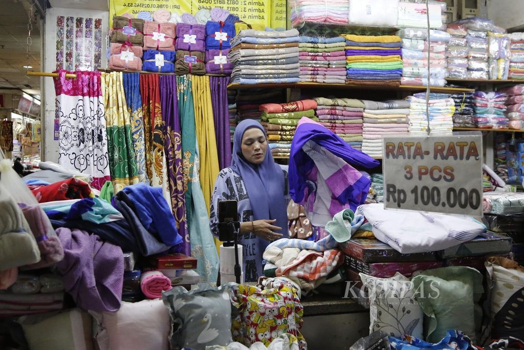 Traders sell via live broadcast or live social media at Tanah Abang Market, Jakarta, Thursday (21/12/2023). Tiktok has reopened the shopping feature in its application after synergizing with Tokopedia since mid-December. Traders admit that this method helps boost sales of goods amidst the reduction in visitors coming to their stalls.