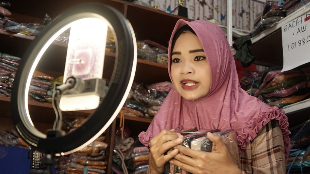 Kiki Wulandari (32) sedang menawarkan jilbabnya melalui lokapasar di rumahnya yang ada Kabupaten Banyuasin, Sumatera Selatan, Sabtu (27/11/2021). Sejak masa pandemi penggunaan platform digital meningkat. 