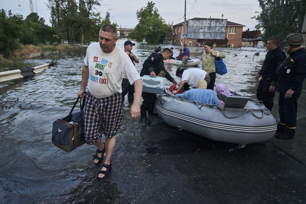 Petugas mengevakuasi warga dengan perahu karet dari permukiman-permukiman yang dibanjiri air bah menyusul jebolnya Bendungan Kakhovka di Kherson, Ukraina, Selasa (6/6/2023). 