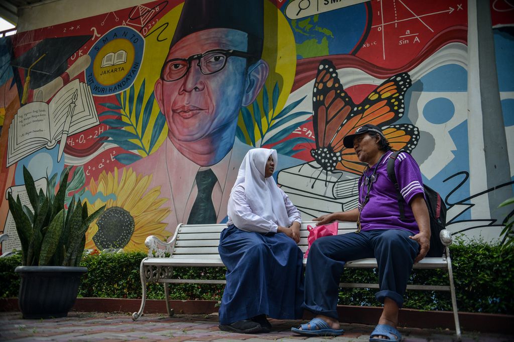 Orangtua dan calon siswa beristirahat di SMAN 70 Jakarta, Senin (12/6/2023), setelah melakukan pendaftaran. Pendaftaran dan seleksi PPDB DKI Jakarta dibuka mulai dari 12 Juni hingga 14 Juni 2023. 