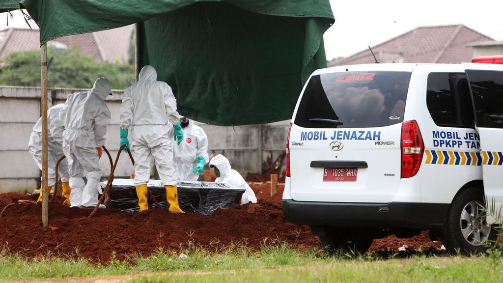 Petugas pemakaman menguburkan jenazah pasien Covid-19 di TPU Jombang, Tangerang Selatan, Sabtu (4/4/2020). 