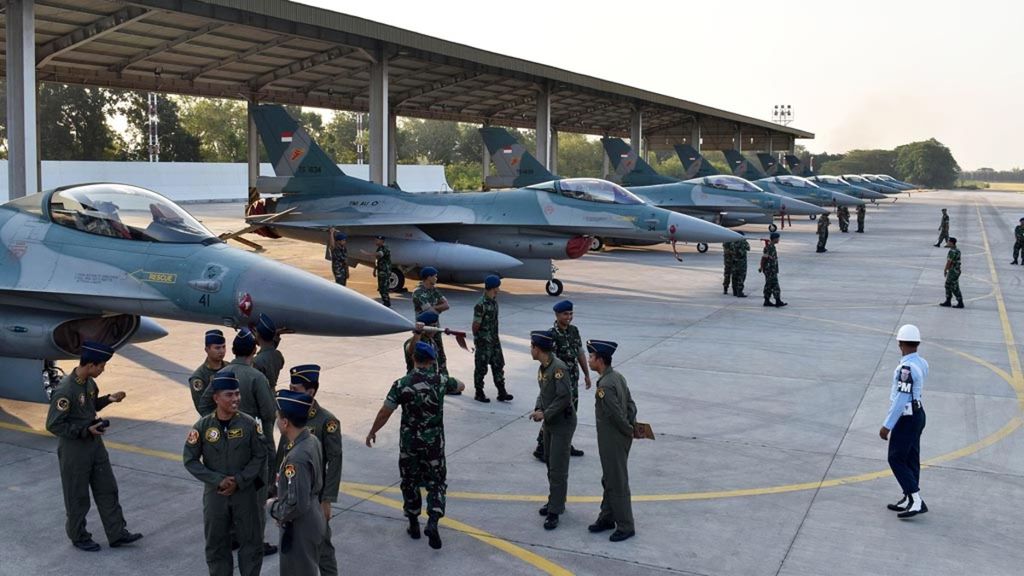 A number of fighter pilots are chatting near the row of F-16 fighter jets after a departure ceremony for the F-16 fighter jets heading to Australia to participate in multinational combat training, at Iswahjudi Air Force Base in Magetan, East Java (24/7/2018).