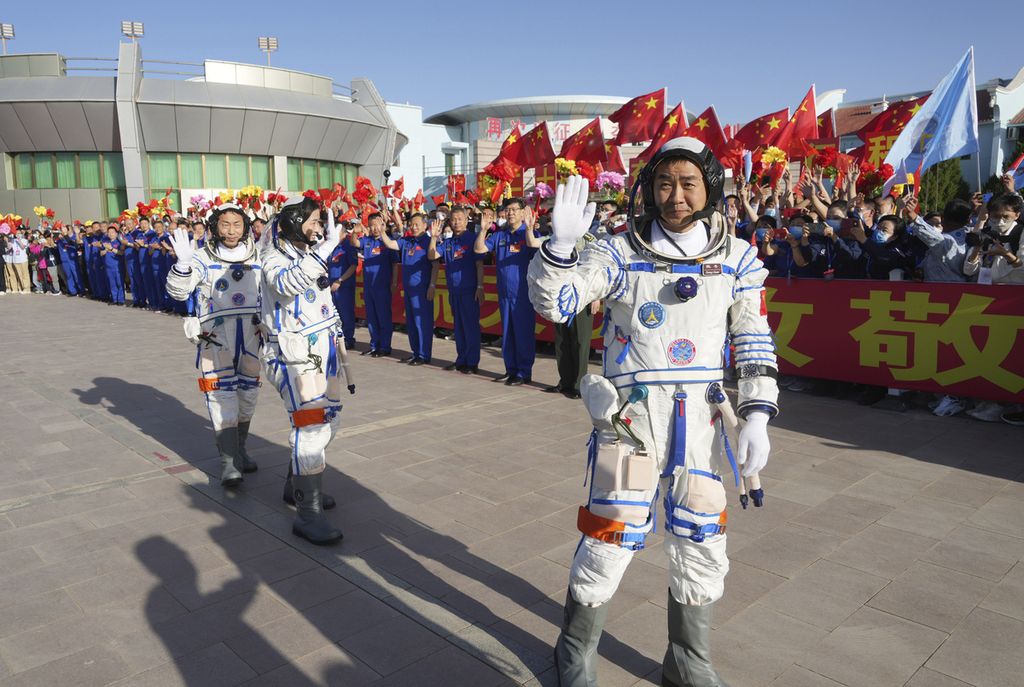 Dalam foto yang dirilis kantor berita China, Xinhua, astronot China Chen Dong (kanan) melambaikan tangan. Di belakangnya, dua astronot lainnya, Liu Yang and Cai Xuzhe. Foto diambil pada upacara pelepasan di Pusat Peluncuran Satelit Jiuquan di wilayah China bagian utara, Minggu (5/6/2022). 
