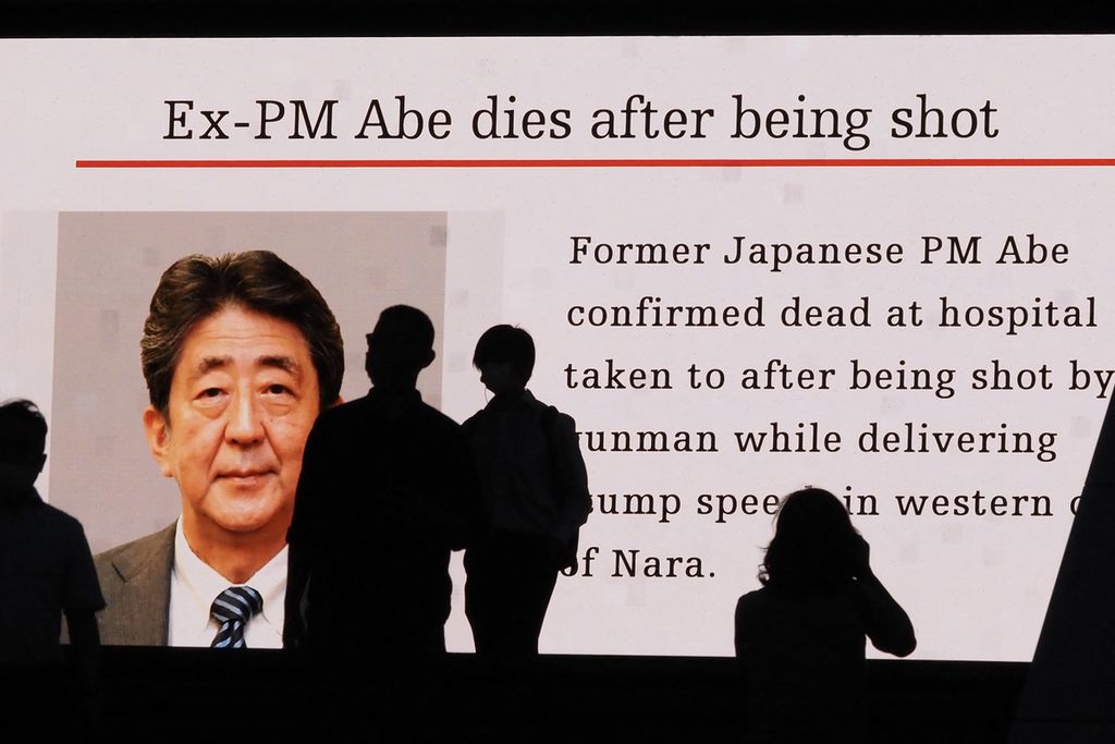Pengguna jalan di Tokyo, Jepang, Jumat (8/7/2022), menyaksikan video yang mengabarkan kematian mantan Perdana Menteri  Jepang Shinzo Abe yang ditembak Tetsuya Yamagami di Nara, wilayah barat daya Jepang, pada Jumat. 