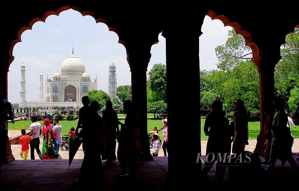 Rombongan wisatawan menikmati kawasan wisata  kompleks Taj Mahal di Agra, India, awal Juli lalu. Perjalanan wisata yang tumbuh di tingkat global turut menopang pertumbuhan ekonomi.