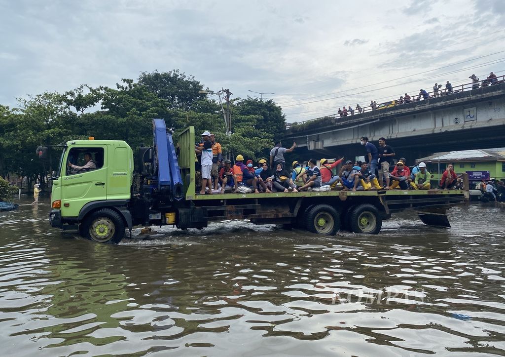 The truck carried a number of workers to pass through the tidal flood at the entrance to Tanjung Emas Port, Semarang, North Semarang District, Semarang City, Central Java, Wednesday (25/5/2022).