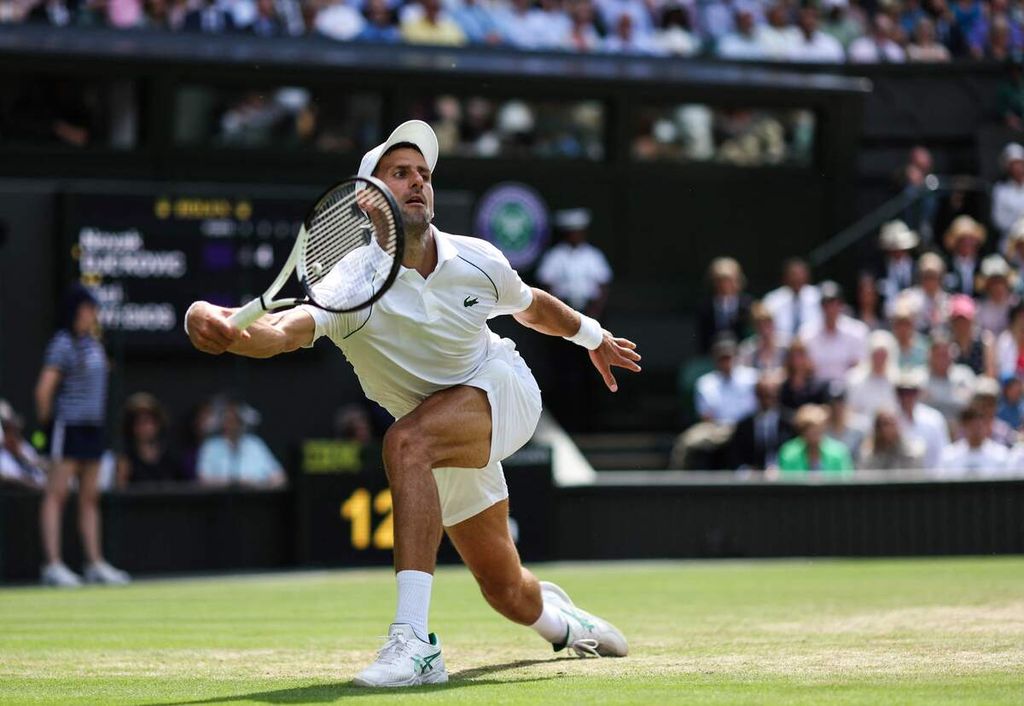Novak Djokovic mengembalikan bola saat melawan Nick Kyrgios pada laga final tunggal putra turnamen tenis Grand Slam Wimbledon di The All England Tennis Club, Wimbledon, London, Minggu (10/7/2022). 
