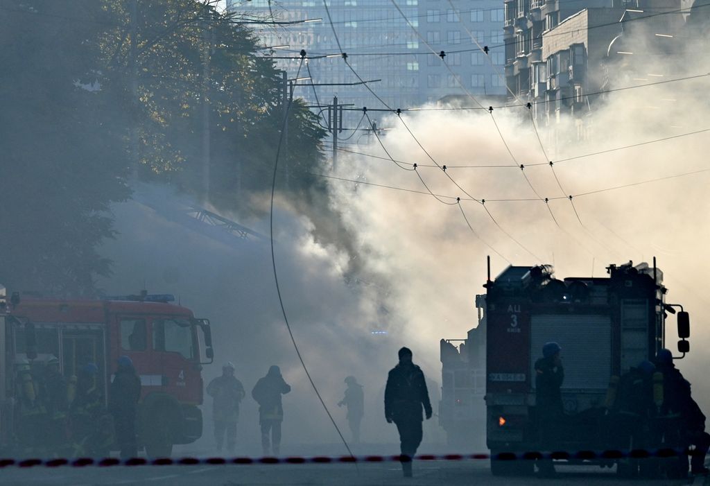 Asap mengepul di jalan saat petugas pemadam kebakaran Ukraina bersiap setelah serangan pesawat tak berawak di Kyiv, Ukraina, Senin (17/10/2022). Ibu kota Kyiv telah diserang empat kali pada pagi hari oleh Rusia dengan pesawat tak berawak.