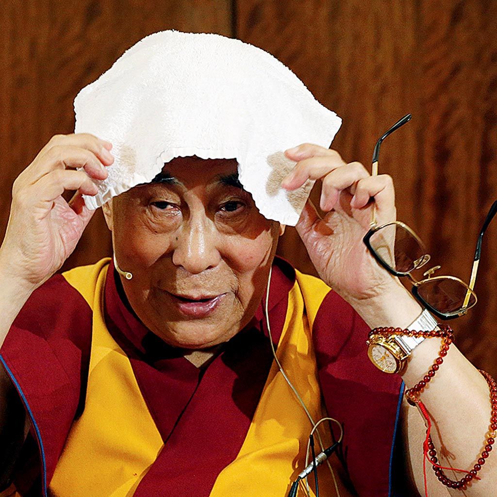 Pemimpin spritual Tibet, Dalai Lama, meletakkan handuk di kepalanya dalam sebuah jumpa pers di Paris, Perancis, 13 September 2016. 