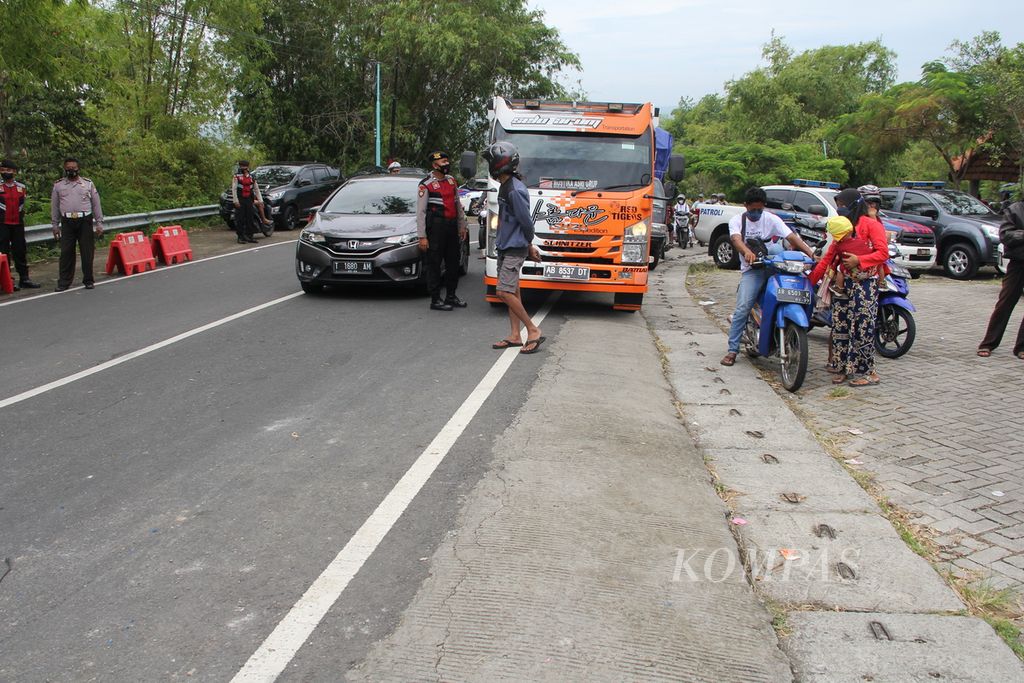 Sejumlah pengendara kendaraan bermotor diminta berhenti sementara karena polisi sedang melakukan olah tempat kejadian perkara kecelakaan bus pariwisata di Jalan Imogiri-Dlingo, Kabupaten Bantul, DIY, Senin (7/2/2022). 