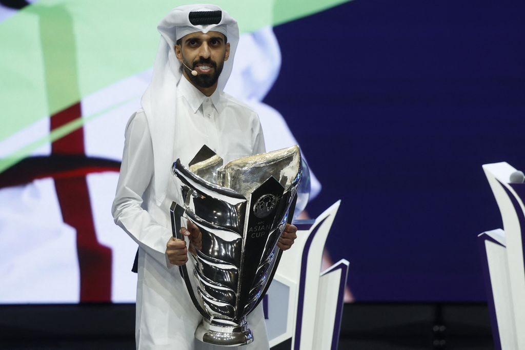 Hassan al-Haydos, gelandang dan kapten tim nasional Qatar, membawa trofi Piala Asia pada agenda pengundian babak penyisihan Piala Asia 2023 di Doha, Qatar, Kamis (11/5/2023). Qatar bertekad mempertahankan gelar juara di rumah sendiri.