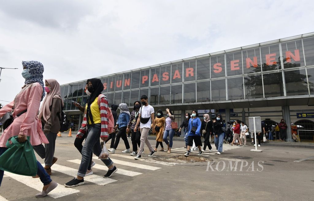 Sejumlah penumpang kereta berjalan meninggalkan Stasiun Pasar Senen, Jakarta Pusat, Kamis (11/3/2021).