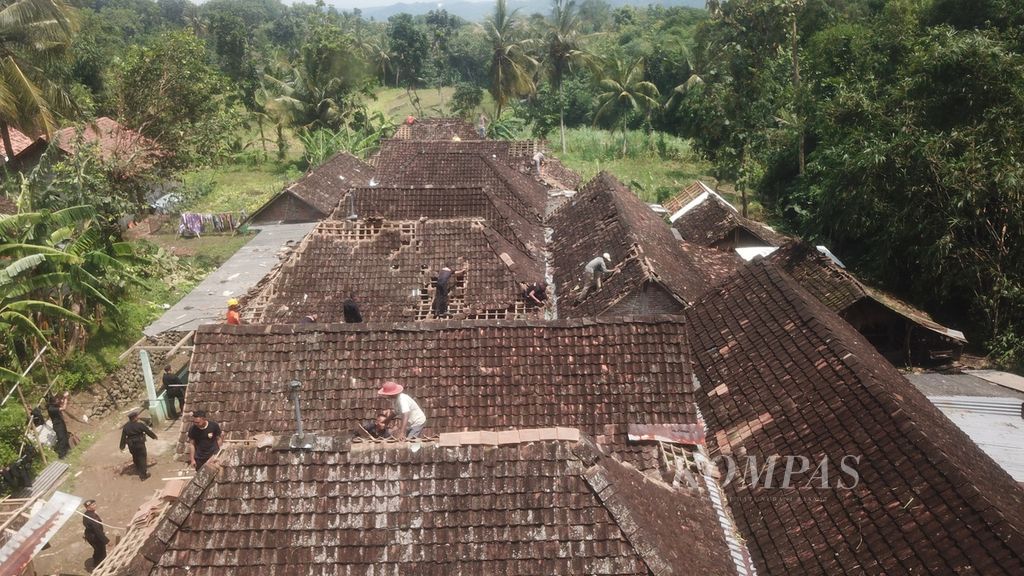 Sukarelawan bersama warga bergotong royong memperbaiki atap rumah yang rusak terkena puting beliung di Dusun Kalidadap II, Desa Selopamioro, Imogiri, Bantul, DI Yogyakarta, Rabu (7/12/2022).  