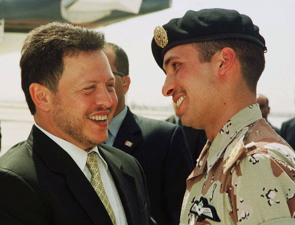 Foto yang diambil pada 2 April 2001 memperlihatkan Raja Jordania Abdullah II (kiri) tersenyum kepada saudara tirinya, Pangeran Hamzah bin Al Hussein (kanan), saat bertemu di bandara jelang keberangkatan ke Amerika Serikat. 