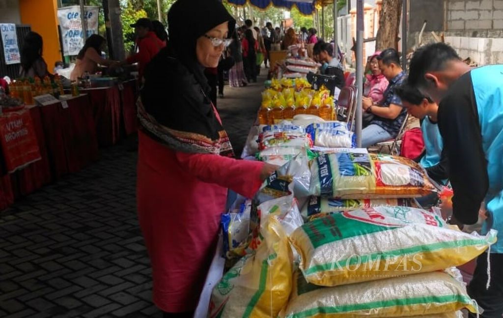 Warga membeli beras saat bazar pasar murah di Siwalankerto, Surabaya, Jawa Timur, Kamis (2/5/2019).