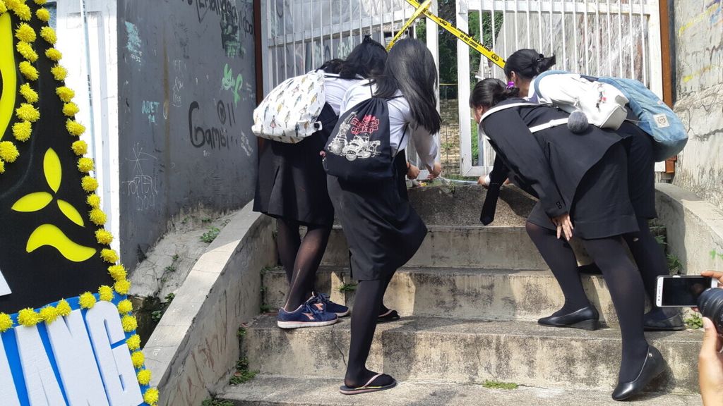 Empat siswa SMK Baranangsiang meletakkan bunga di depan pagar gang tempat terbunuhnya salah satu siswi SMK itu, Kamis (10/1/2019) sore.