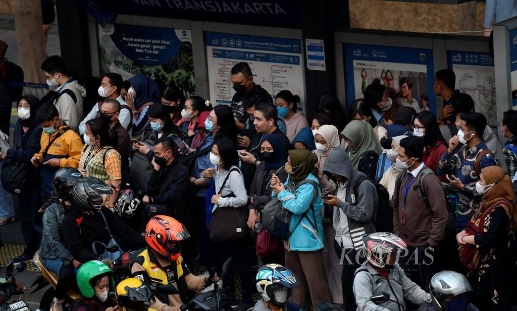 Para pekerja yang sebagian besar mengenakan masker menunggu di salah satu halte Transjakarta di Jalan Sudirman, Jakarta, saat jam pulang kerja, Selasa (29/8/2023). 