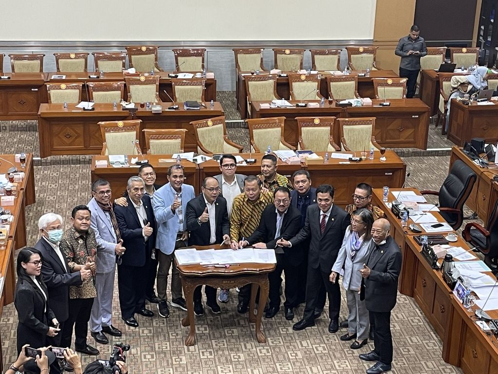 A number of DPR Commission III factions took a photo with Deputy Minister of Law and Human Rights Eddy Omar Sharif Hiariej after approving the ratification of Criminal Code bill in level I discussions, at the Parliament Complex, Jakarta, Thursday (24/11/2022).