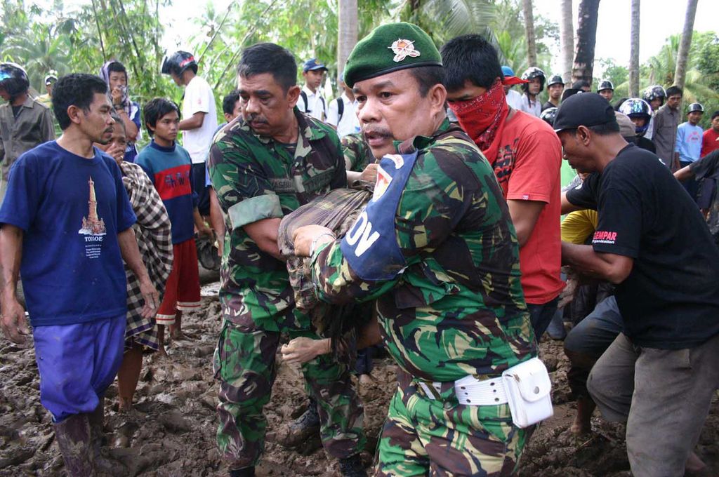 Sejumlah aparat TNI dibantu warga setempat, Rabu (21/6/2006), mengevakuasi korban yang tertimbun reruntuhan rumah mereka yang diterjang banjir bandang pada Selasa dini hari di Kabupaten Sinjai, Sulawesi Selatan. Banjir tersebut mengakibatkan ratusan warga tewas.