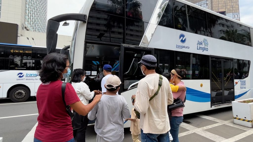 Penumpang mengantre masuk bus tingkat wisata di halte Wisma Nusantara, Jakarta, Selasa (3/5/2022).